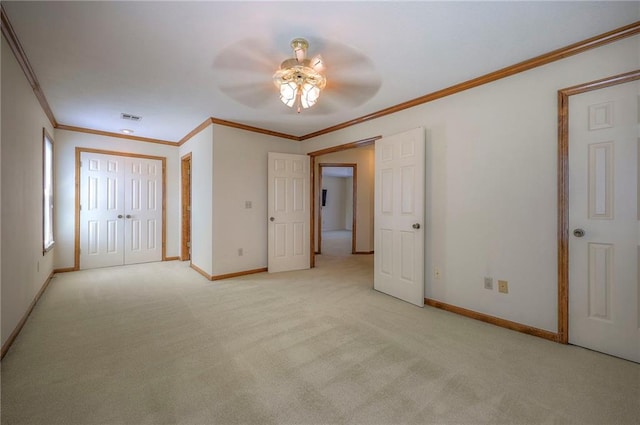 carpeted spare room featuring crown molding and ceiling fan