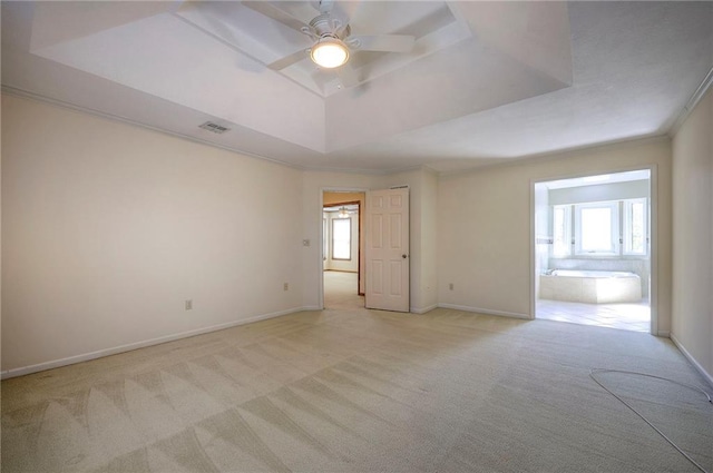 carpeted spare room featuring ceiling fan, plenty of natural light, a raised ceiling, and crown molding