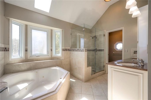 bathroom featuring vanity, vaulted ceiling with skylight, tile patterned floors, and shower with separate bathtub