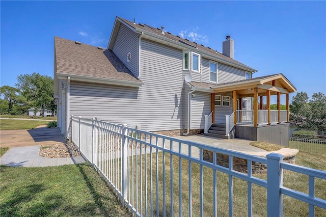 back of house featuring a lawn, a garage, and a porch