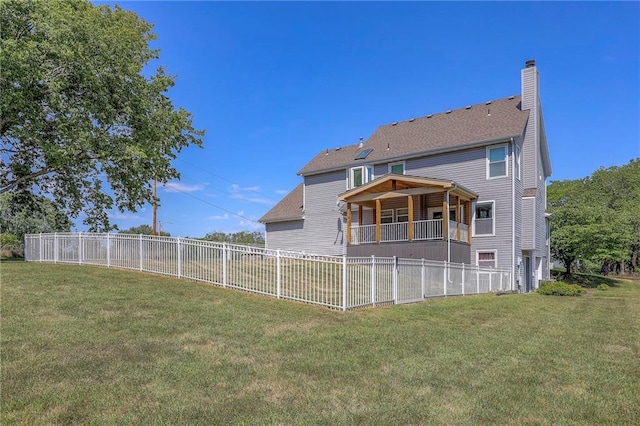 rear view of property with a yard