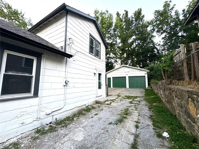 view of side of home with a garage and an outbuilding