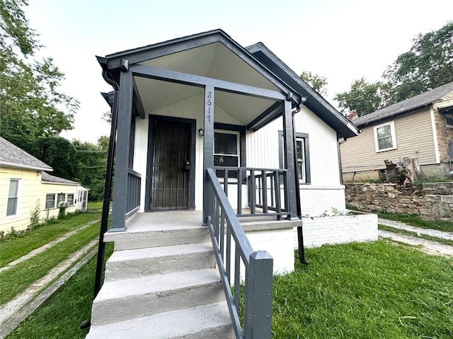 view of front of home with a front yard and covered porch