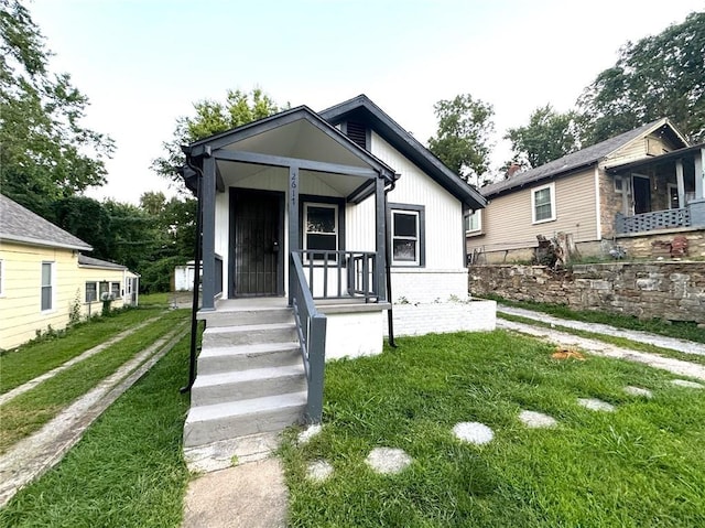 bungalow with a front yard and a porch