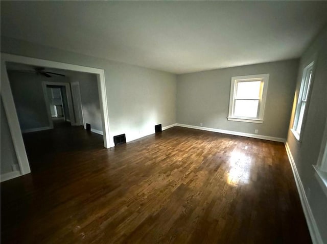 spare room with ceiling fan and dark hardwood / wood-style floors