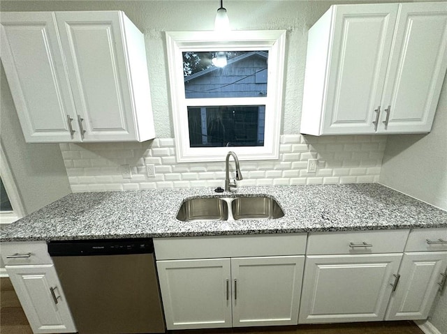 kitchen with sink, tasteful backsplash, light stone counters, and dishwasher