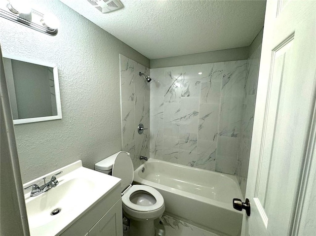 full bathroom with tiled shower / bath, a textured ceiling, vanity, and toilet