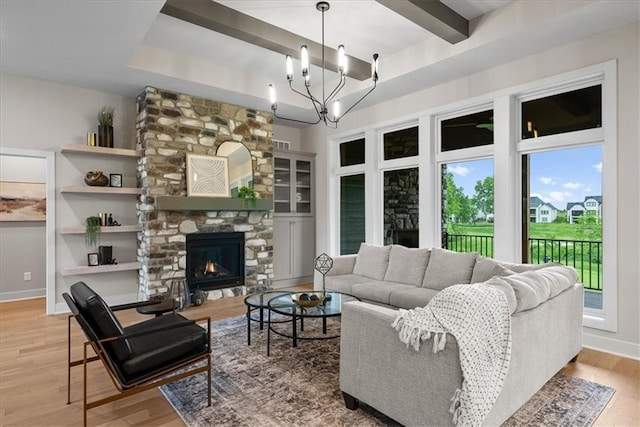 8720 N Lewis Ave, Kansas City, MO 64157 - living area featuring wood finished floors, a chandelier, a fireplace, baseboards, and a raised ceiling