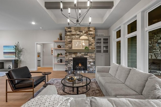 8720 N Lewis Ave, Kansas City, MO 64157 - living area featuring light wood-style flooring, a raised ceiling, baseboards, a large fireplace, and recessed lighting