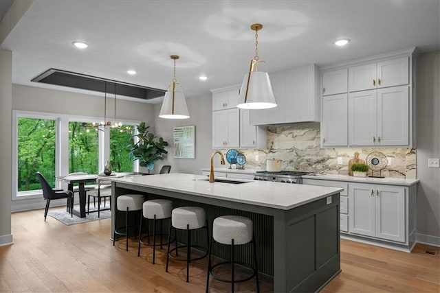 8720 N Lewis Ave, Kansas City, MO 64157 - kitchen with a sink, decorative backsplash, light wood finished floors, light countertops, and recessed lighting