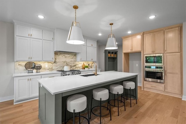 8720 N Lewis Ave, Kansas City, MO 64157 - kitchen with appliances with stainless steel finishes, a sink, decorative backsplash, light wood finished floors, and recessed lighting