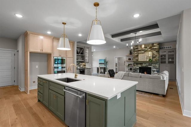 8720 N Lewis Ave, Kansas City, MO 64157 - kitchen with green cabinetry, appliances with stainless steel finishes, a sink, a fireplace, and light countertops