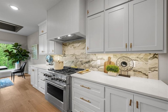 8720 N Lewis Ave, Kansas City, MO 64157 - kitchen with high end stove, premium range hood, light countertops, light wood-type flooring, and tasteful backsplash