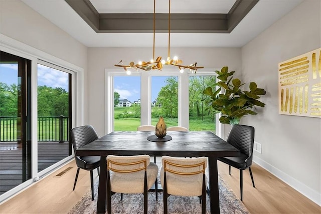 8720 N Lewis Ave, Kansas City, MO 64157 - dining space featuring healthy amount of natural light, light wood-style flooring, a chandelier, and baseboards