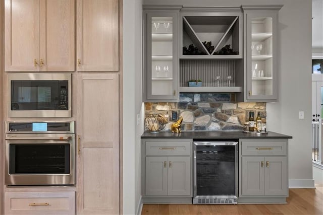 8720 N Lewis Ave, Kansas City, MO 64157 - indoor dry bar with stainless steel oven, wine cooler, built in microwave, and light wood finished floors