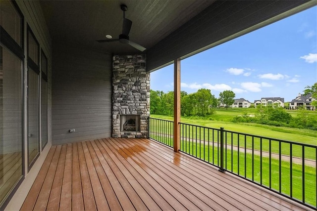 8720 N Lewis Ave, Kansas City, MO 64157 - deck with ceiling fan, an outdoor stone fireplace, a lawn, and a residential view