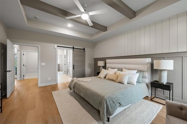 8720 N Lewis Ave, Kansas City, MO 64157 - bedroom with a barn door, light wood-style flooring, baseboards, beam ceiling, and a ceiling fan
