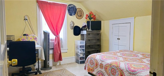 carpeted bedroom featuring lofted ceiling and a closet