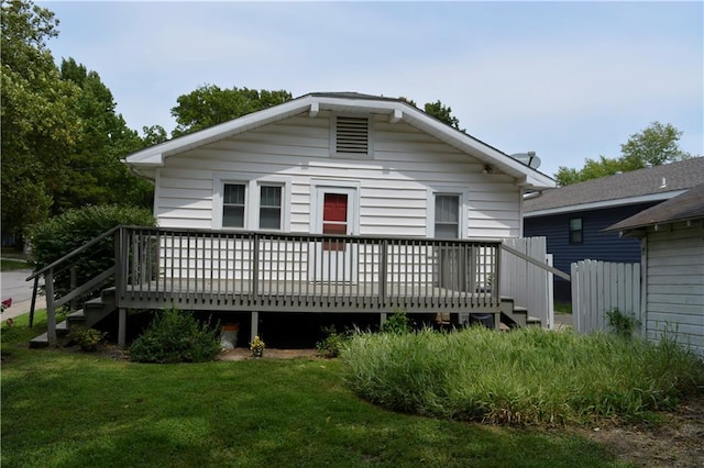 rear view of house with a yard and a deck