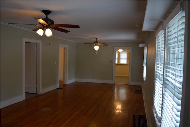 unfurnished room with ornamental molding, wood finished floors, visible vents, and baseboards