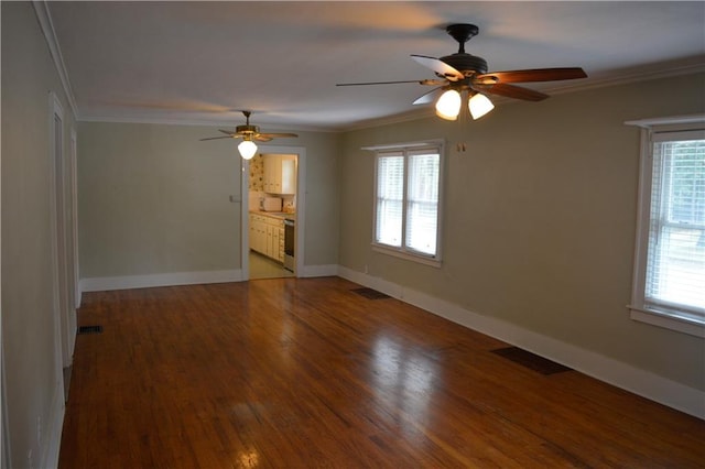 empty room with a healthy amount of sunlight, visible vents, and ornamental molding