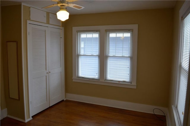 unfurnished bedroom featuring a closet, baseboards, and wood finished floors