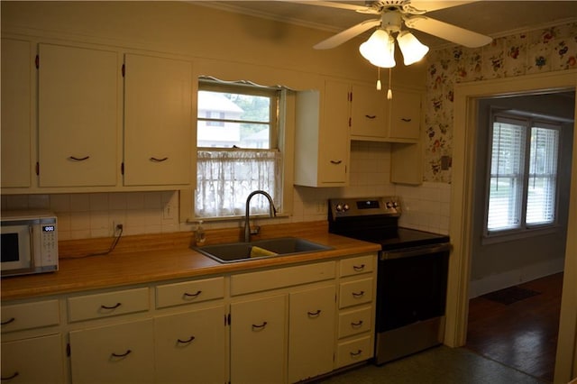 kitchen featuring light countertops, electric range, white microwave, white cabinets, and a sink