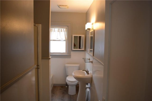 bathroom featuring toilet, visible vents, and wood finished floors