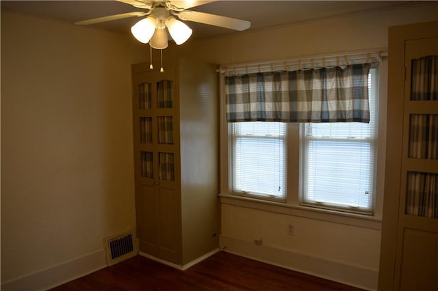 unfurnished dining area featuring a ceiling fan, baseboards, visible vents, and dark wood-style flooring