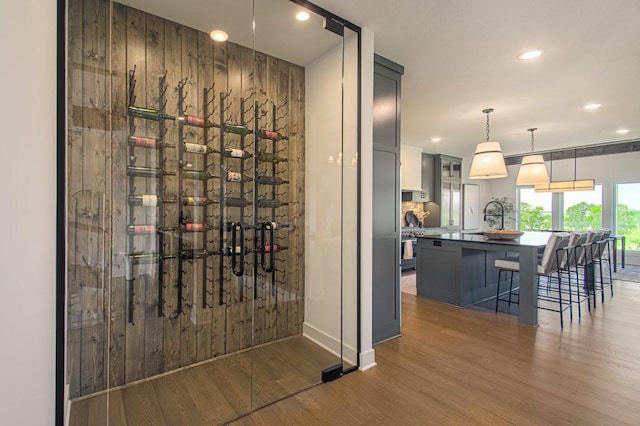 wine cellar featuring recessed lighting, wooden walls, and wood finished floors