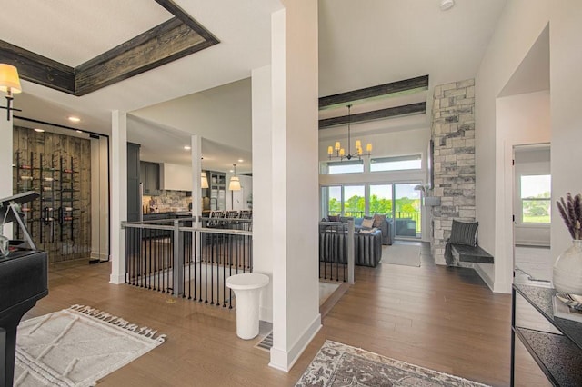 hallway featuring a chandelier, wood finished floors, and baseboards