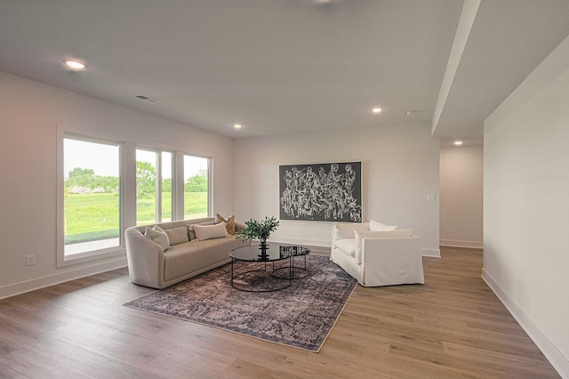 living room with baseboards, wood finished floors, and recessed lighting