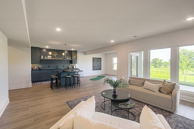 living room with light wood-style floors, a wealth of natural light, and recessed lighting