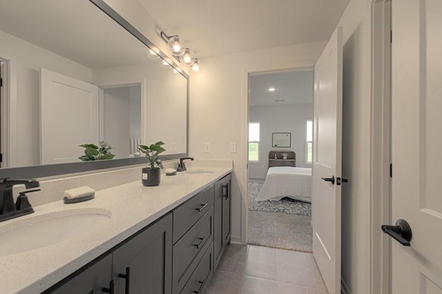 full bathroom featuring double vanity, tile patterned flooring, connected bathroom, and a sink