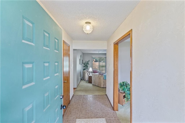 carpeted entryway featuring a textured ceiling