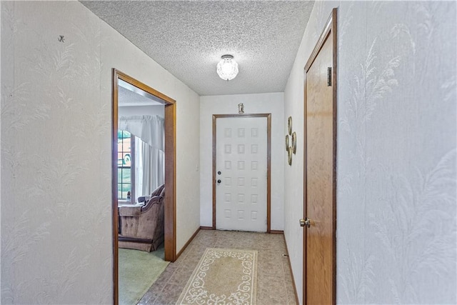 doorway to outside featuring a textured ceiling and light tile patterned floors