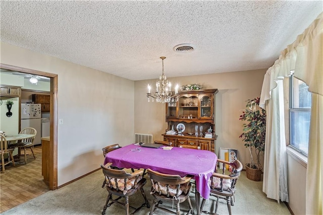 dining room featuring ceiling fan with notable chandelier, hardwood / wood-style flooring, and a textured ceiling