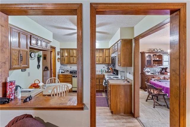 kitchen with a textured ceiling and light carpet