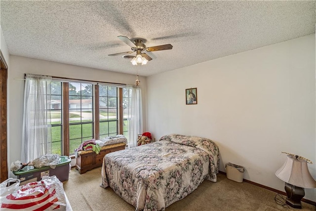 carpeted bedroom with multiple windows, a textured ceiling, and ceiling fan