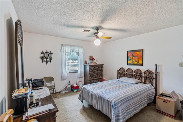 bedroom with ceiling fan, light carpet, and a textured ceiling