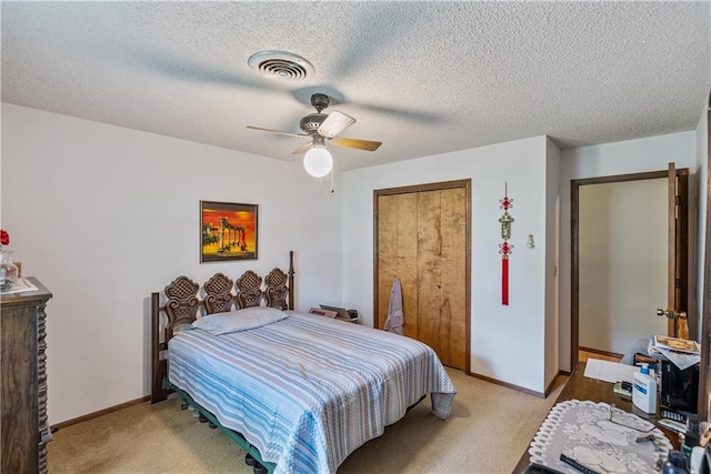 bedroom with a textured ceiling, ceiling fan, and light colored carpet