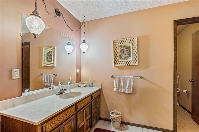 bathroom with tile patterned flooring, a textured ceiling, and vanity