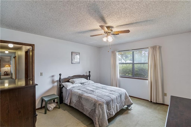 bedroom with ceiling fan, a textured ceiling, and light colored carpet