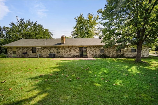 back of house featuring cooling unit and a yard