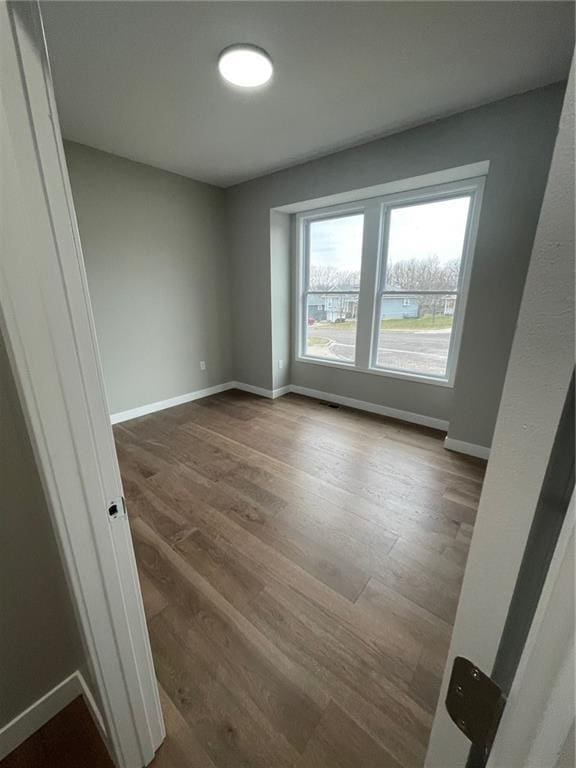 unfurnished room with wood-type flooring