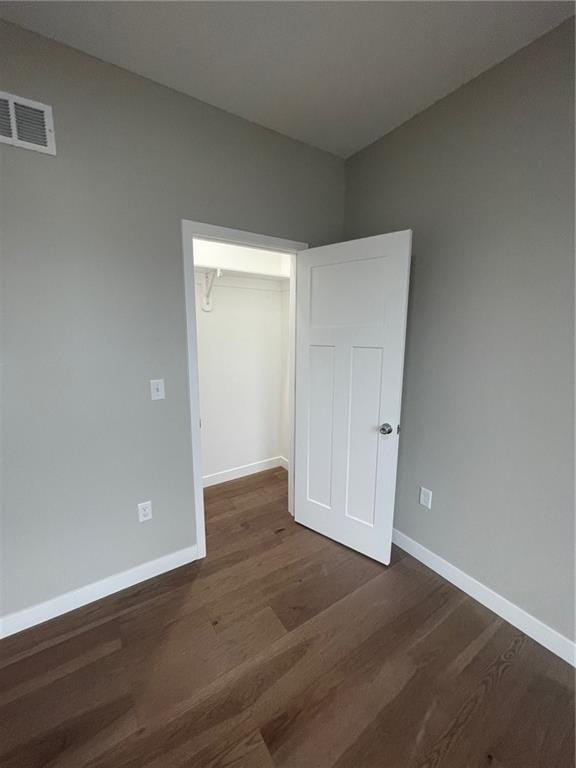 unfurnished bedroom featuring dark hardwood / wood-style flooring and a closet