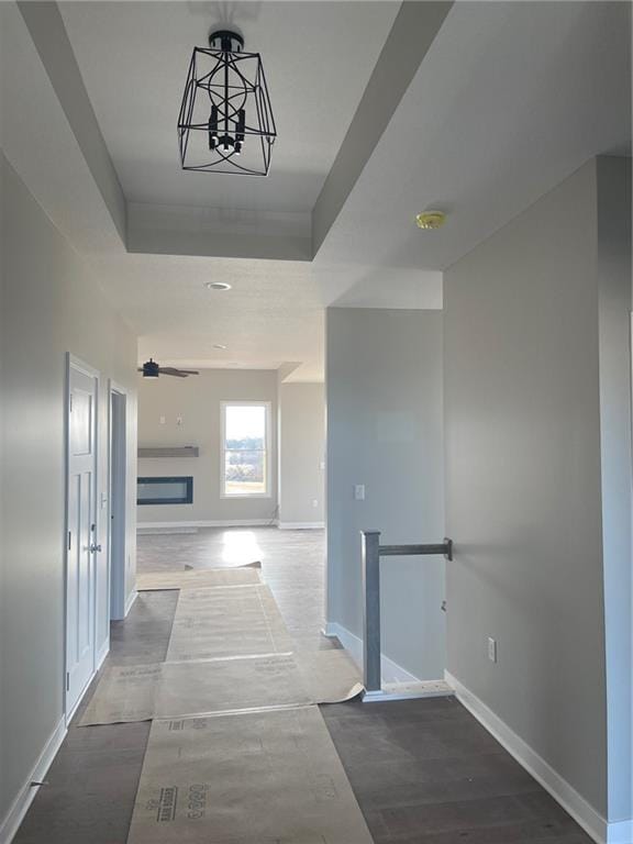 hallway featuring a tray ceiling and hardwood / wood-style flooring