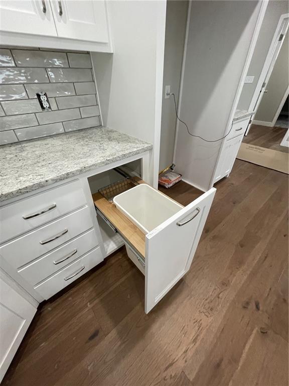 kitchen featuring white cabinetry, dark hardwood / wood-style flooring, and light stone countertops