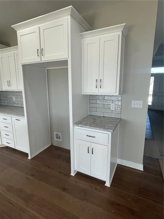 kitchen with white cabinetry, light stone countertops, and dark wood-type flooring