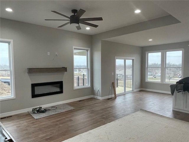 unfurnished living room featuring hardwood / wood-style flooring and ceiling fan